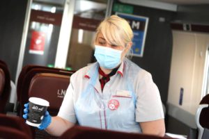A woman serves a drink onboard a train