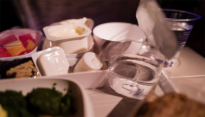 Discarded food packaging on a plane tray table.