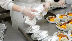 hands in plastic gloves packaging food