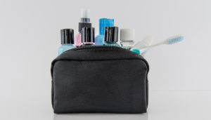 An amenity kit with plastic bottles and toothbrush