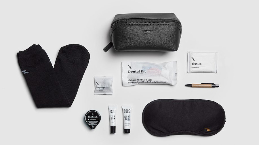 An amenity kit with socks, sleeping mask, tissue, laying on a white background.