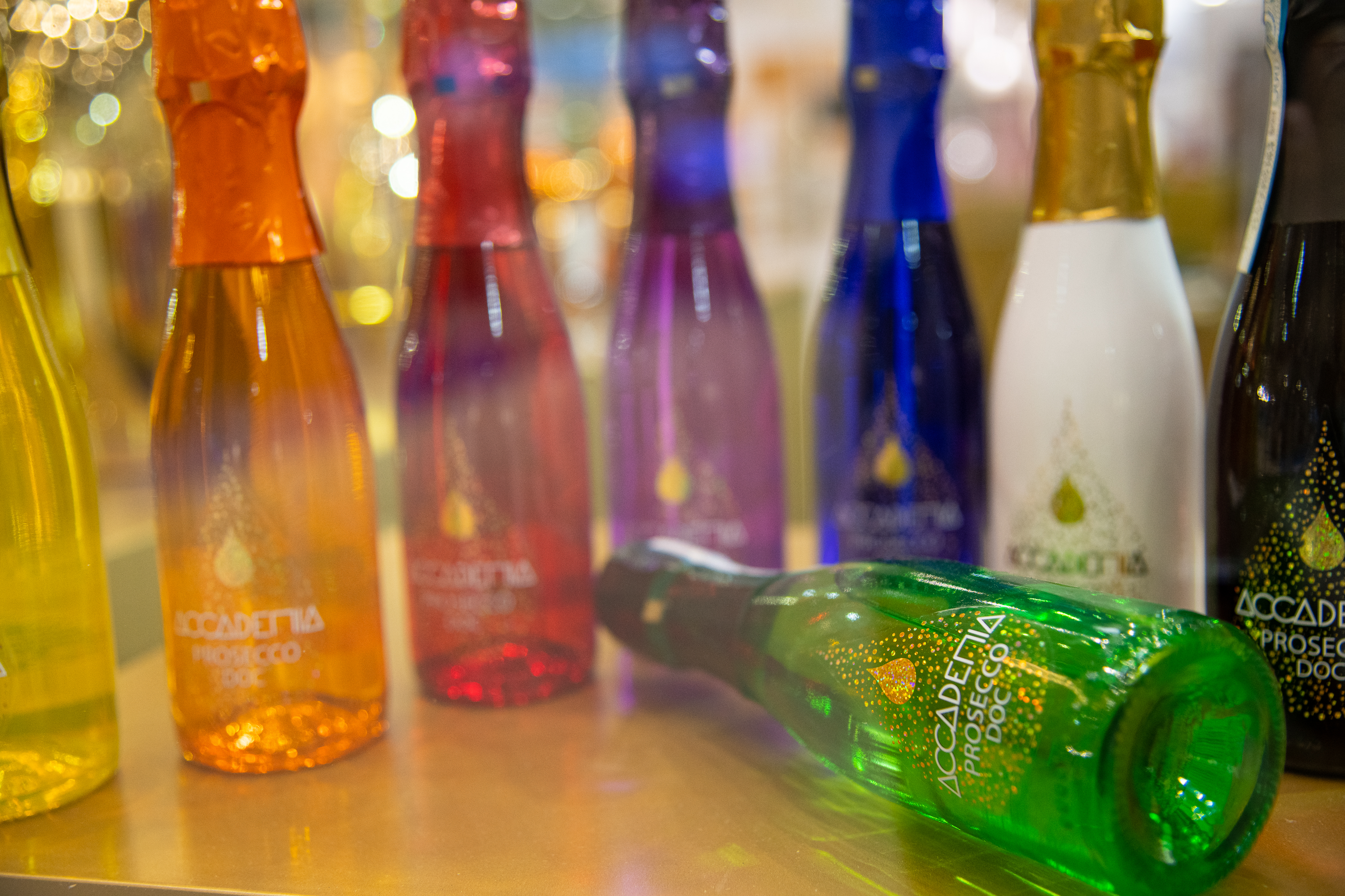 row of multi-coloured small prosecco bottles