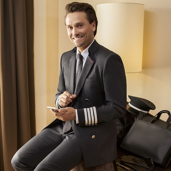 man seated in airline pilots uniform