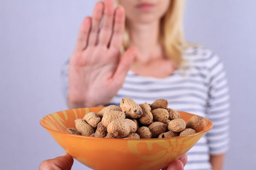 woman holding her hand out no to a bowl of nuts