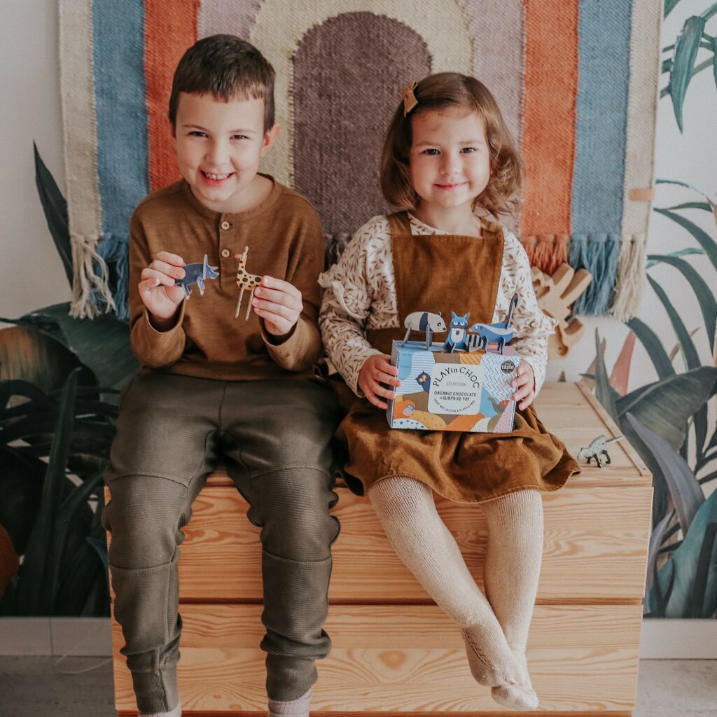 two children sat on a box with playin choc products