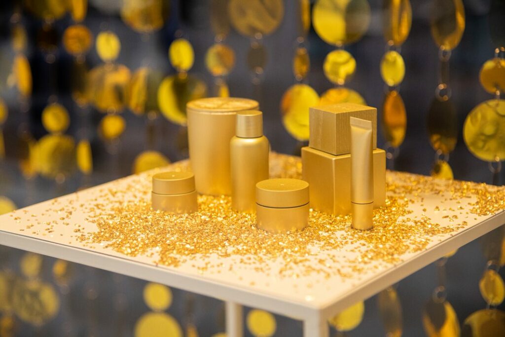 gold covered beauty products on a plinth