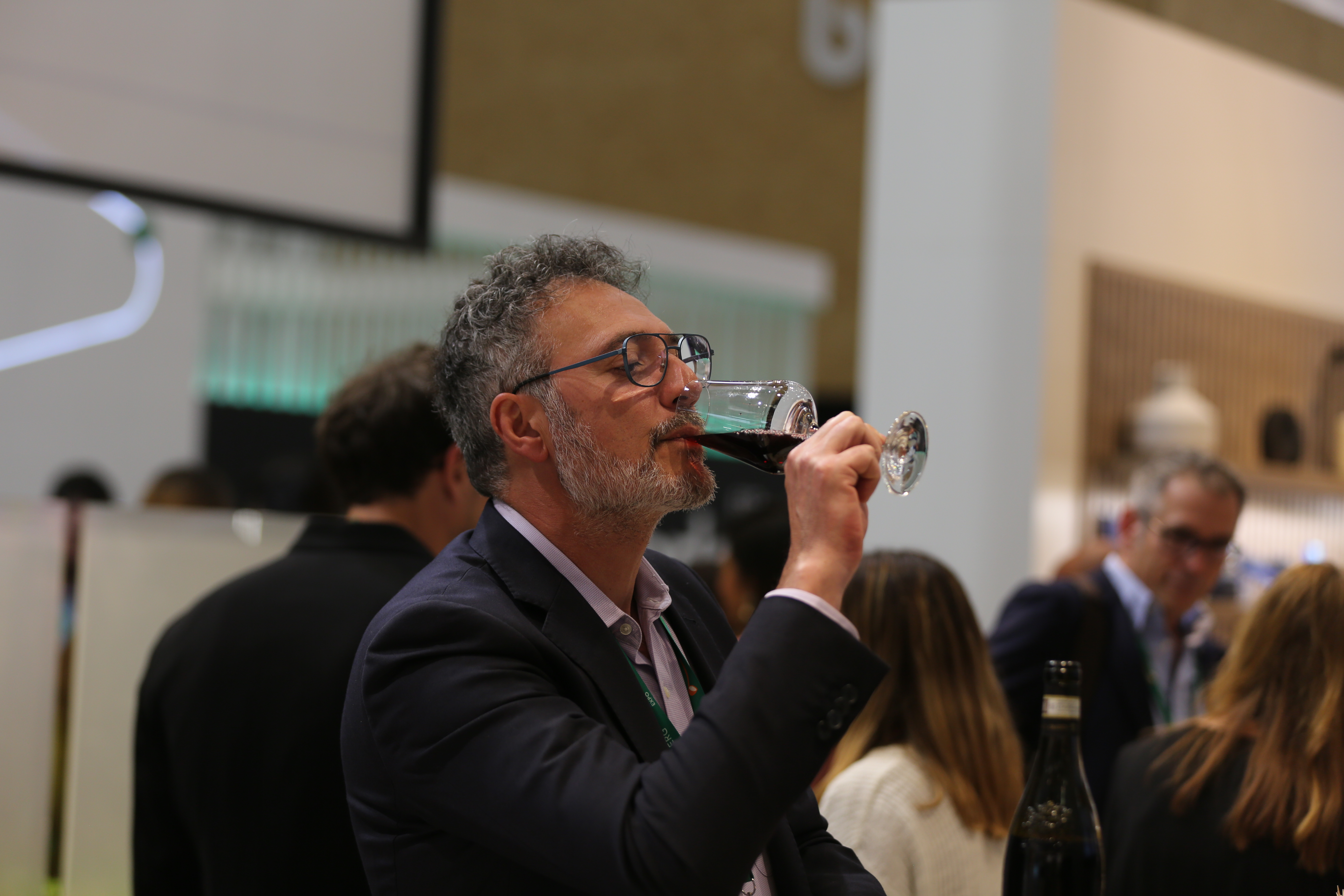 man sampling wine with head back