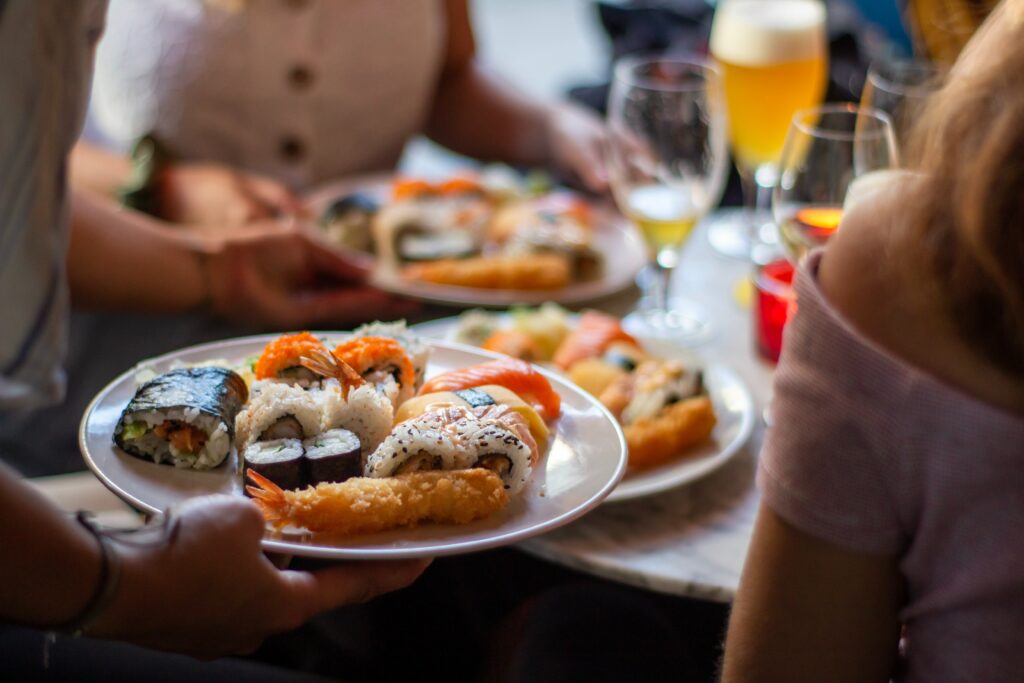 hand holding plate of sushi