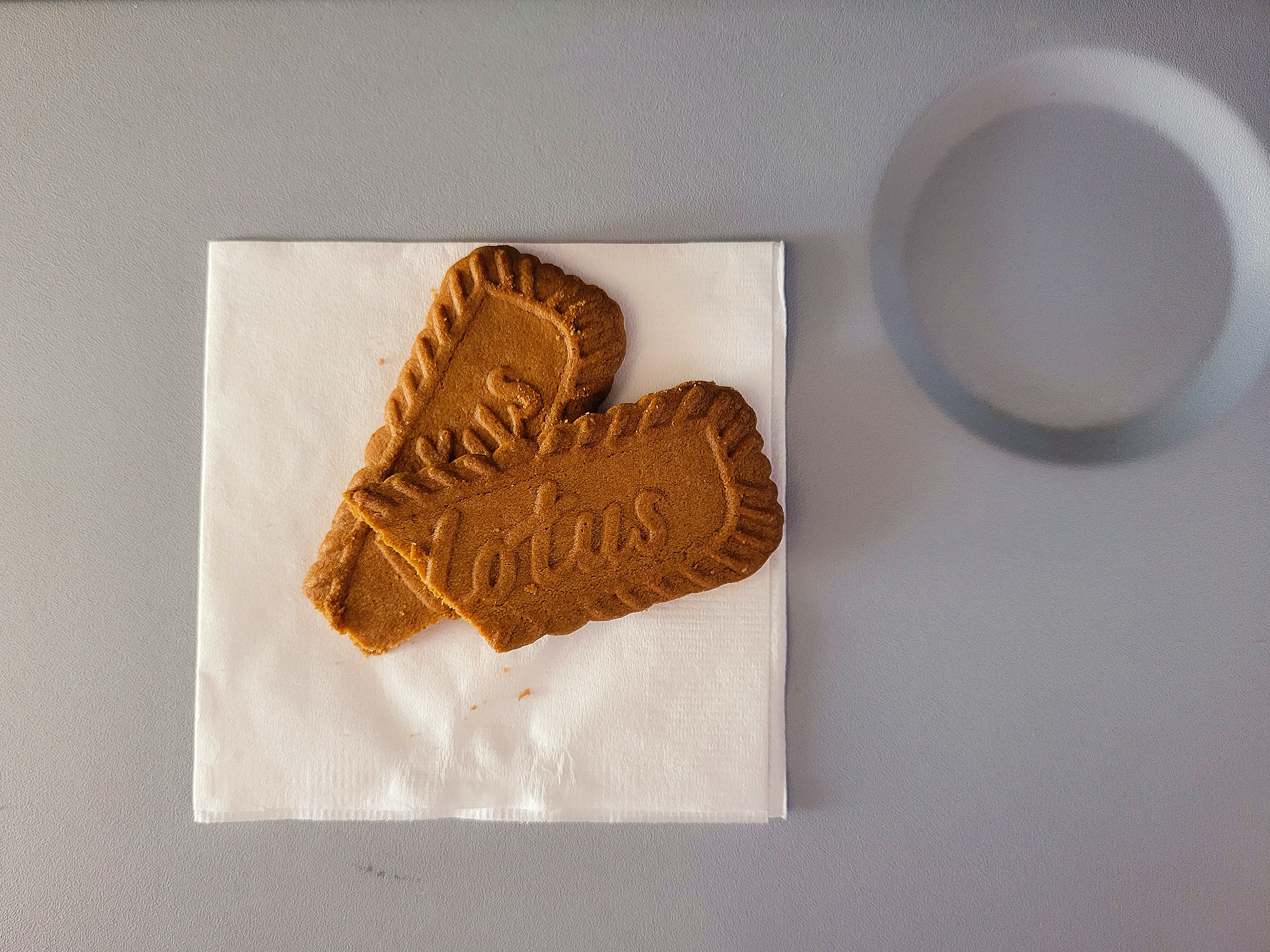 lotus biscoff biscuit on white napkin airline tray table