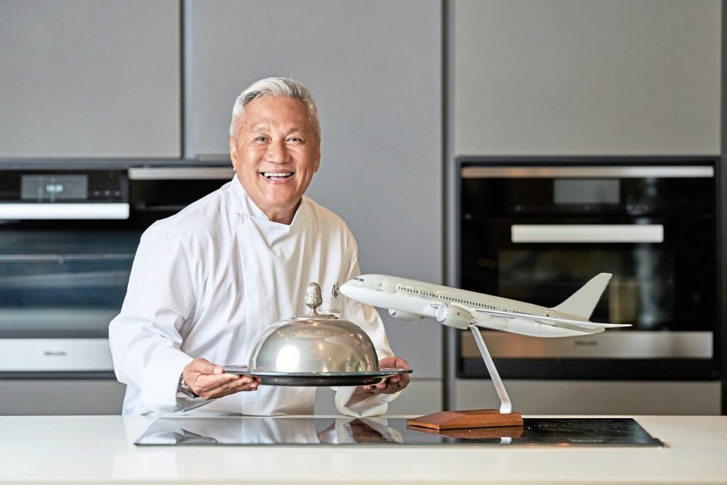 chef wan standing with closh next to aircraft figure