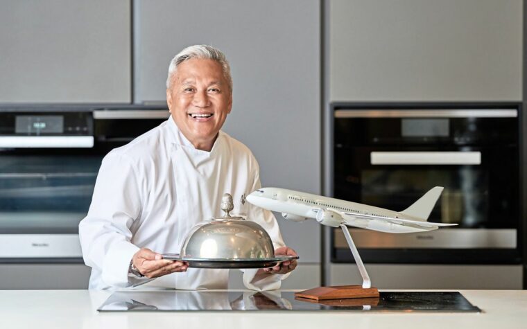 chef wan standing with closh next to aircraft figure
